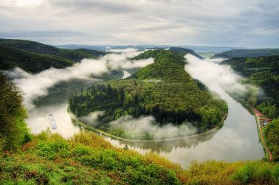 Atemberaubender Blick auf die Saarschleife bei Cloef mit dichtem Morgennebel, grünen Wäldern und ruhig dahinfließendem Fluss – beliebtes Ausflugsziel unweit der Ferienwohnung Ilona.